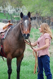 bigstockphoto_Woman_Saddling_Horse_1502213-1