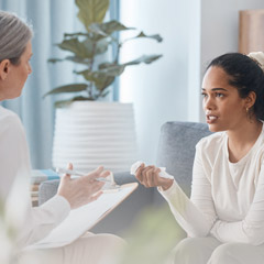 Shot of an attractive young woman sitting and talking to her psychologist during a consultation.