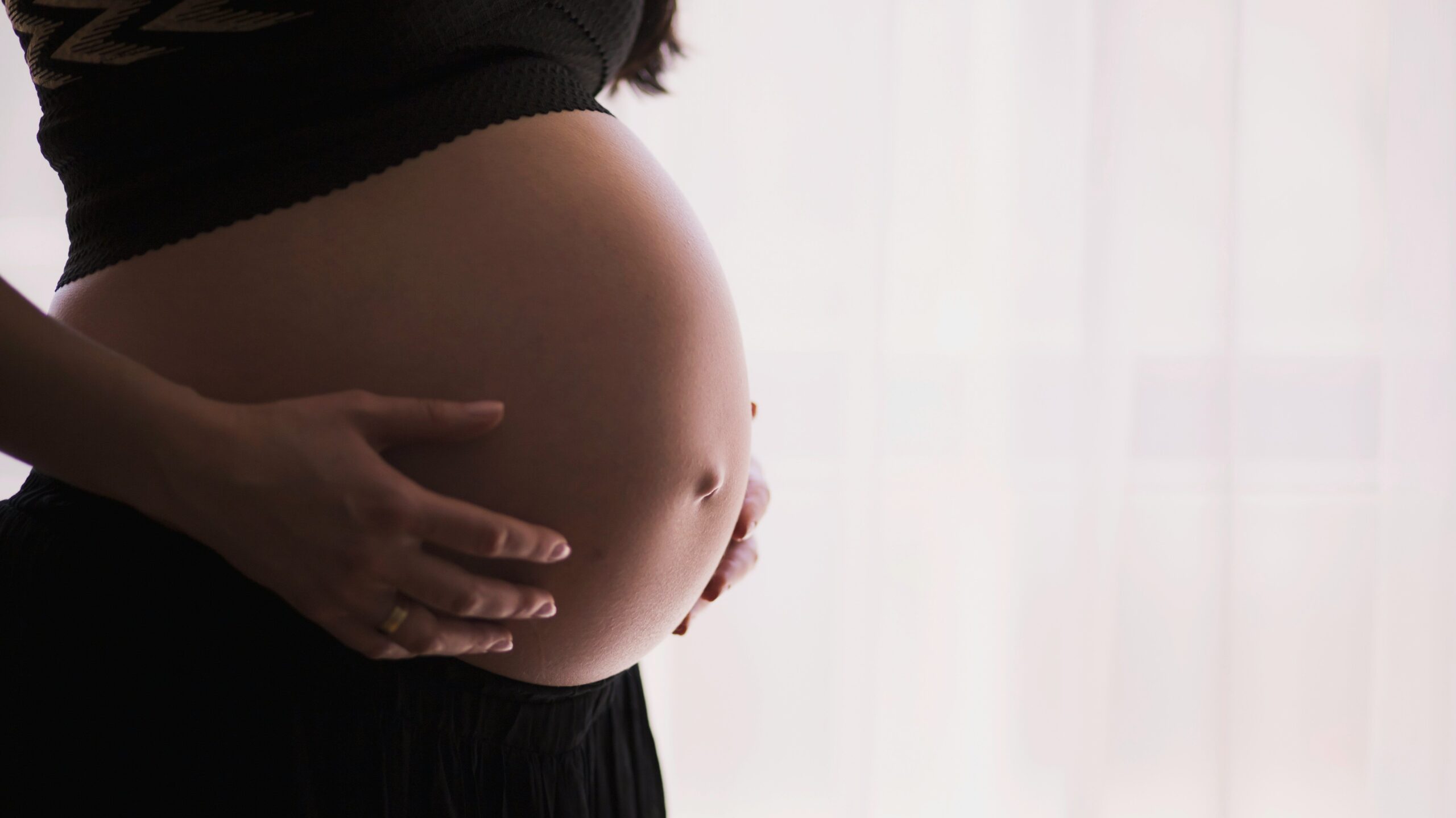 close-up of a woman's pregnant stomach cradled in her hands
